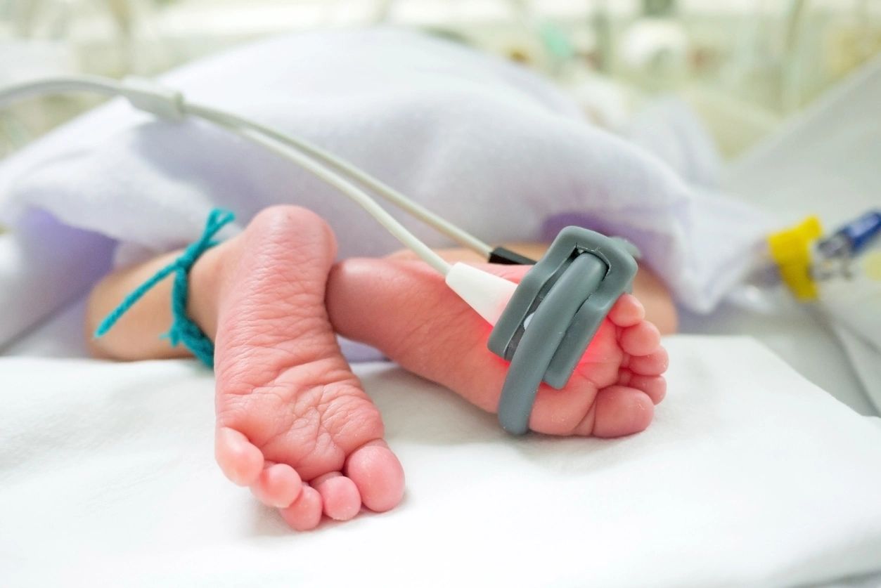 Newborn baby feet with pulse oximeter